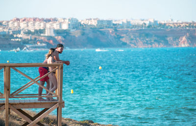 Woman looking at sea against sky