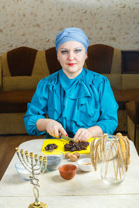 Portrait of young woman with food on table