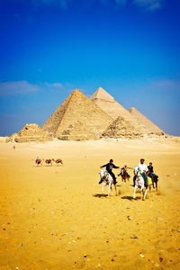 People on sand dune in desert