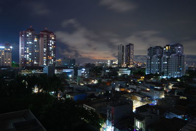 High angle view of illuminated buildings against sky at night