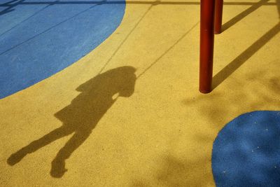 High angle view of shadow of man standing on basketball court