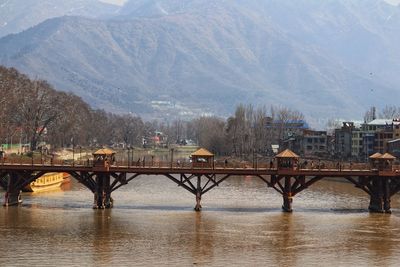 Bridge over river in city against sky