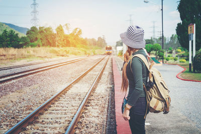 Side view of young woman waiting on railroad station platform