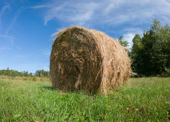 Hay bales on field against sky