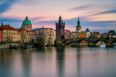 Arch bridge over river against buildings in city