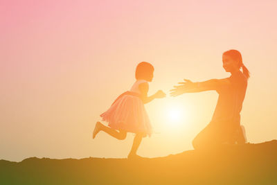Silhouette men standing against sky during sunset