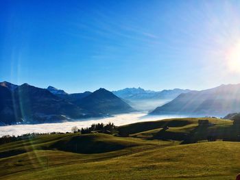 Scenic view of golf course against blue sky