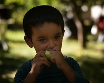 Portrait of cute boy eating food outdoors