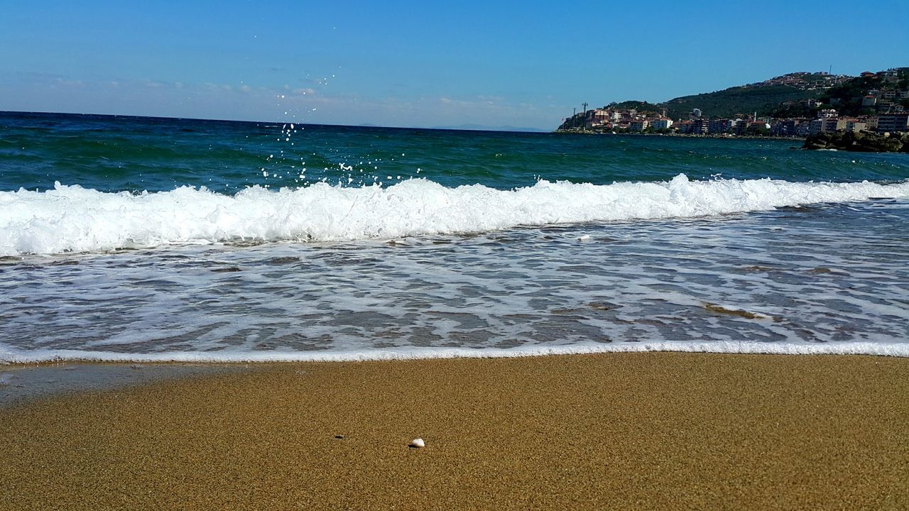 beach, water, sea, surf, sand, shore, wave, scenics, beauty in nature, tranquil scene, seascape, blue, coastline, nature, travel destinations, tourism, tranquility, sky, vacations, day, outdoors, mountain, majestic, non-urban scene, summer, tide, no people, non urban scene