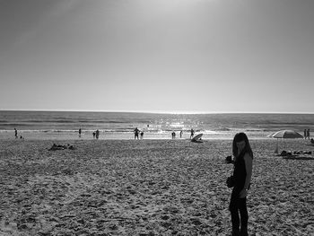 People on beach against clear sky