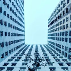 Low angle view of modern buildings against blue sky