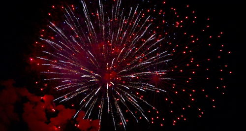 Low angle view of firework display at night