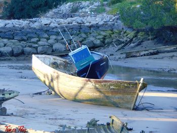 Abandoned boat moored at beach