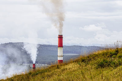 Concept of environmental pollution. pipes with smoke on background of forest and mountain