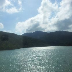 Scenic view of lake and mountains against cloudy sky