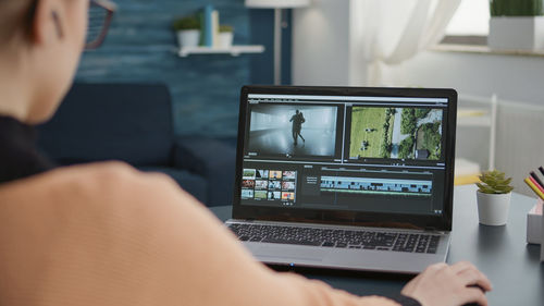 Woman using laptop sitting at desk in office