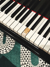 Piano missing a keyc green, black, and white carpet 