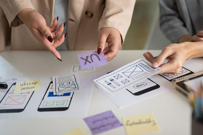 Midsection of business people working on table