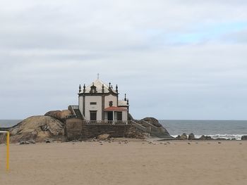 Built structure on beach against sky