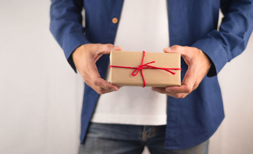 Midsection of man holding hands in box