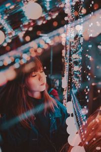 Portrait of girl looking at illuminated lights
