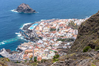 High angle view of townscape by sea against sky