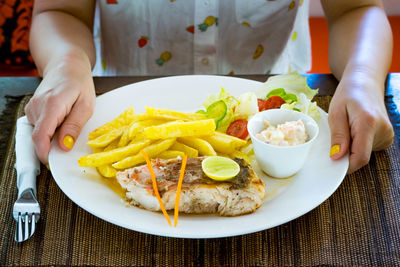 Midsection of person holding food on table