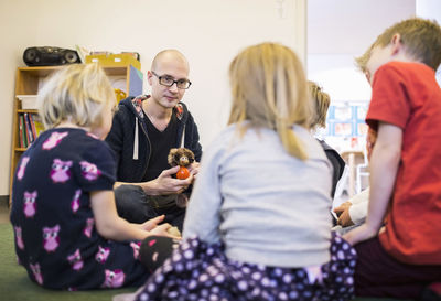 Teacher playing with children in kindergarten