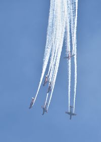 Low angle view of airshow against sky