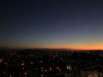 Illuminated cityscape against sky at night