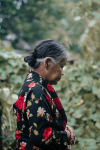 Side view of man looking away while standing outdoors