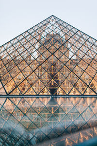 Low angle view of glass building against clear sky