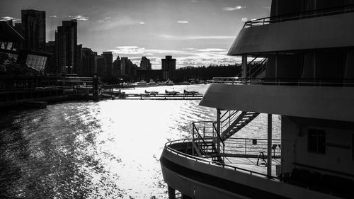 Buildings by river against sky in city