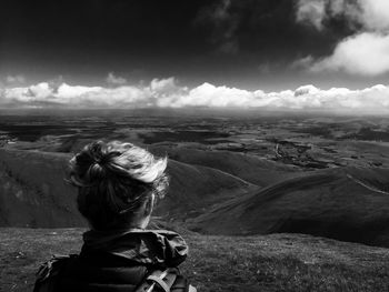 Rear view of woman looking at mountains against sky