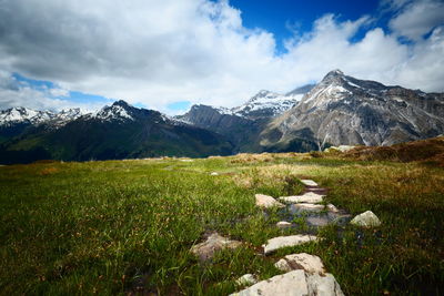 Scenic view of field and mountains against sky