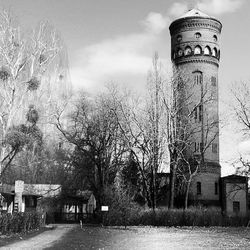Bare trees and buildings against sky