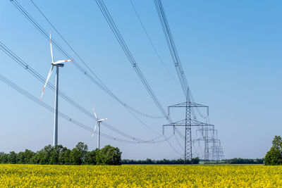 Power supply lines and some wind turbines seen in rural germany