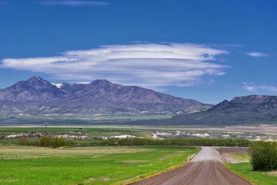 Road leading towards mountains against sky