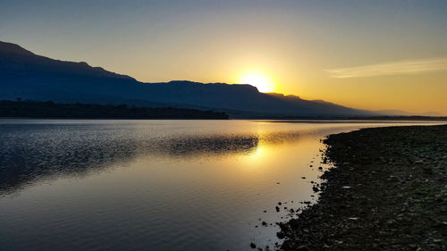 Scenic view of lake against sky during sunset