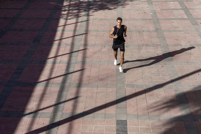 High angle view of man running on footpath