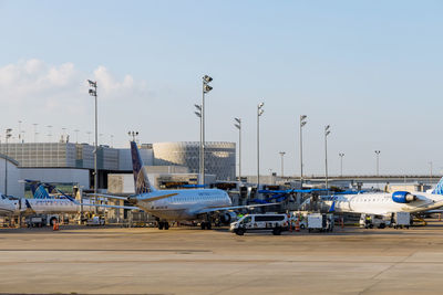 Airplane on airport runway against sky