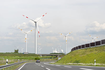 Bonn, germany may 23, 2019. a windmill for electricity production standing in a field along highway.