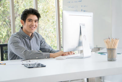 Portrait of young man sitting at table