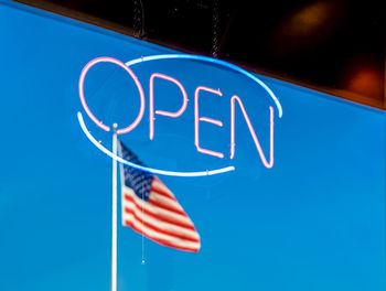 Low angle view of flag against blue sky