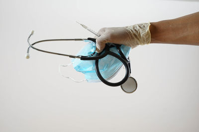 Close-up of hand holding eyeglasses against white background