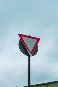 Low angle view of road sign against sky