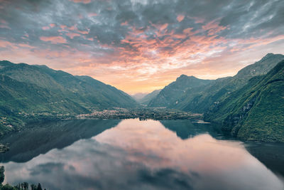 Scenic view of lake and mountains against dramatic sky