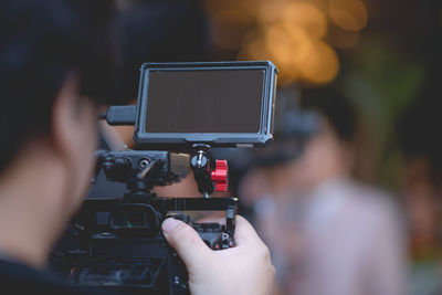 Rear view of man photographing camera