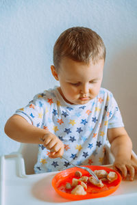 Close-up of cute girl eating food at home