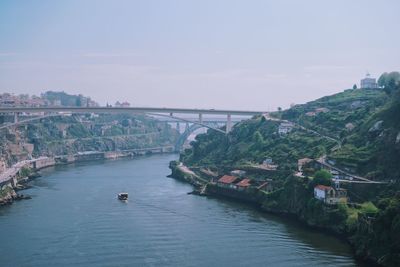Bridge over river in city against sky